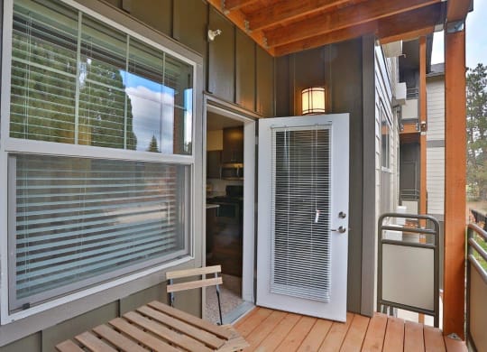 a front porch with a white door and a wooden bench