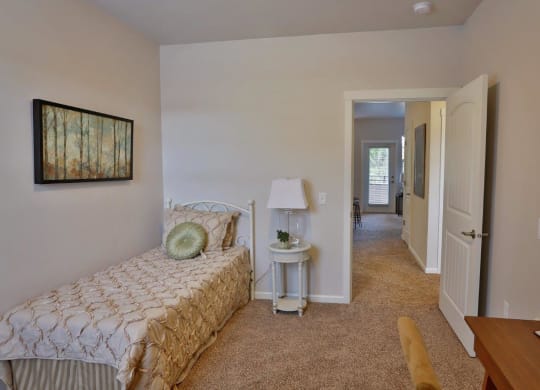 a bedroom with a bed and a hallway with a door