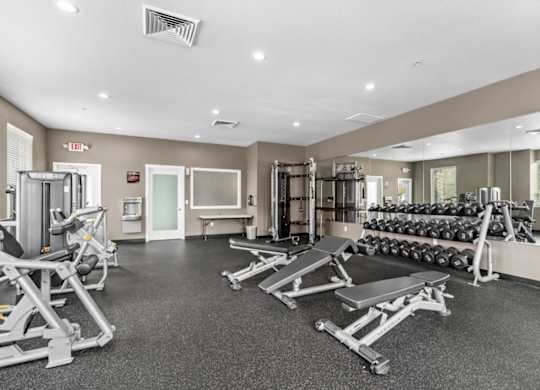 A spacious gym with a variety of equipment including treadmills, weights, and exercise machines.