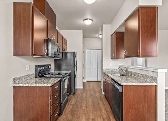 A kitchen with black appliances and wooden cabinets.