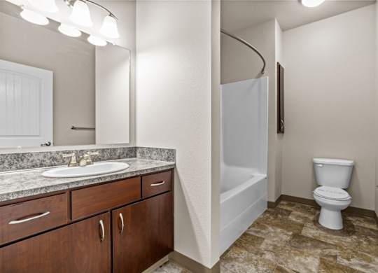 A bathroom with a sink, toilet, and bathtub.