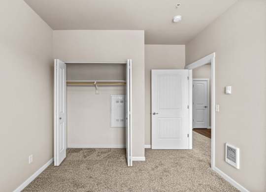 A room with a carpeted floor and a white door.