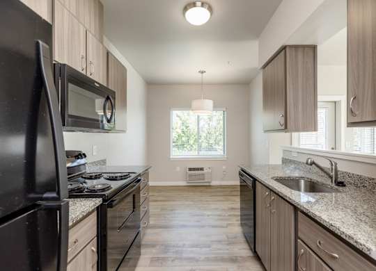 A kitchen with black appliances and wooden cabinets.