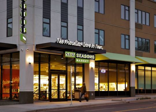 The exterior of a New Seasons grocery store at night.