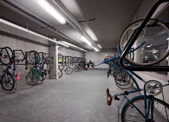 A bike rack with many bikes parked in a garage.