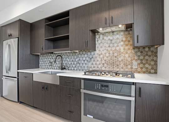 A kitchen with dark wood cabinets and a patterned backsplash.