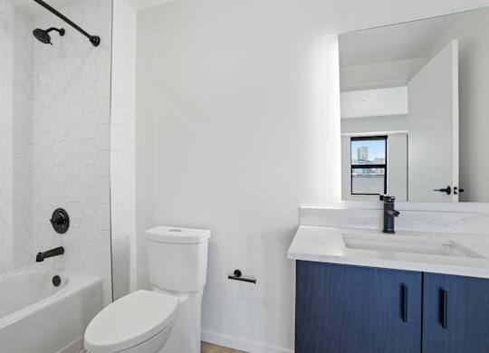 A white toilet sits next to a white sink in a bathroom.