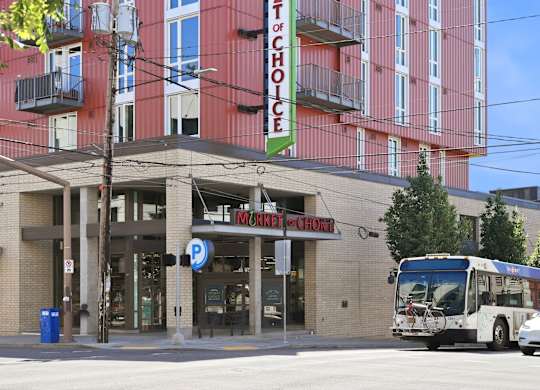 A bus is parked in front of a building with a sign that says