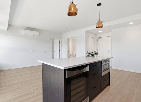 A modern kitchen with a large island and dark wood cabinets.