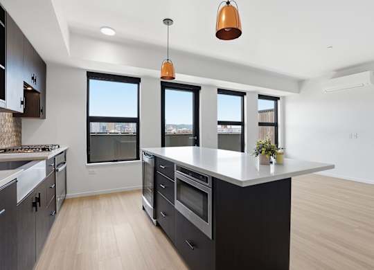 A modern kitchen with a large island and a view of the city.