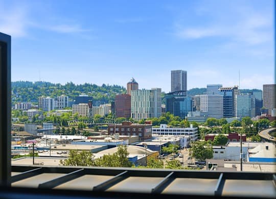 A cityscape with buildings of various heights and a clear blue sky.