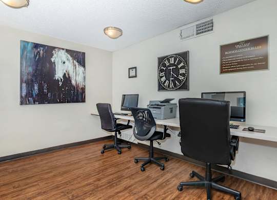 A room with two chairs and a desk with a computer on it.