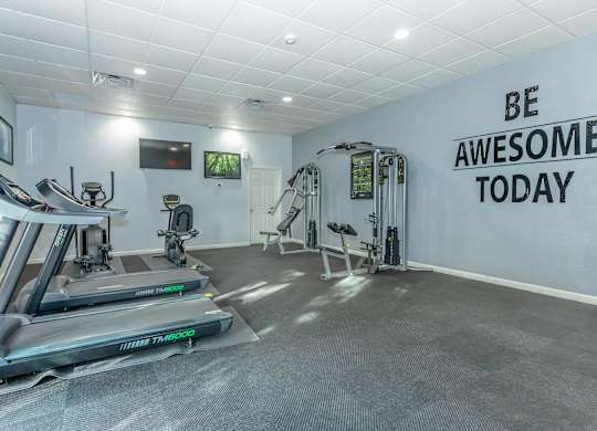 A gym with treadmills and a wall that says "Be Awesome Today".