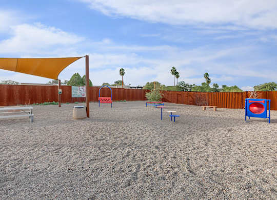 A sandy volleyball court with a net, bench, and ball.