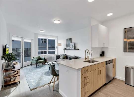 A modern kitchen with a dining area and a living room.