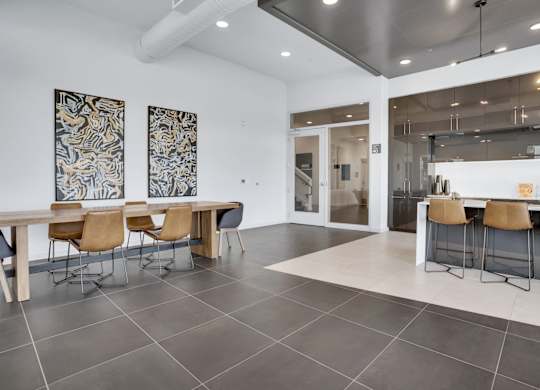 A modern dining room with a long table and chairs.