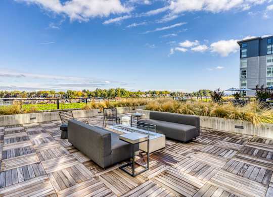 A wooden deck with a table and chairs overlooking a cityscape.