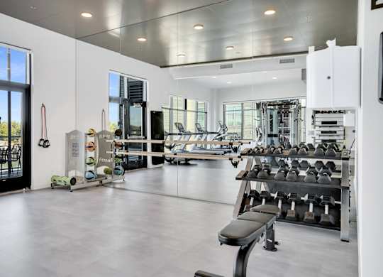 A gym with a variety of equipment including weights and machines.
