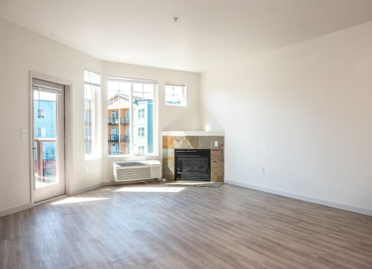 an empty living room with a fireplace and a patio door