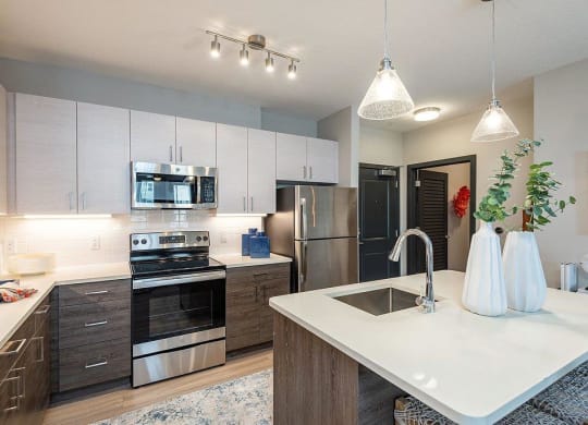 a kitchen with a sink stove refrigerator and microwave