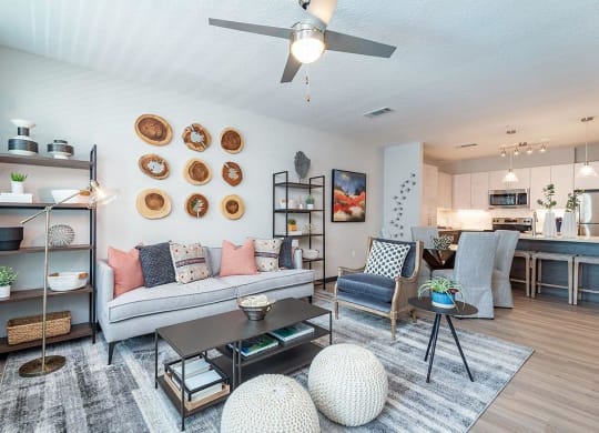 a living room filled with furniture and a ceiling fan