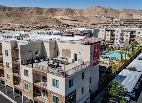 Apartment complex with a pool and a mountain in the background.