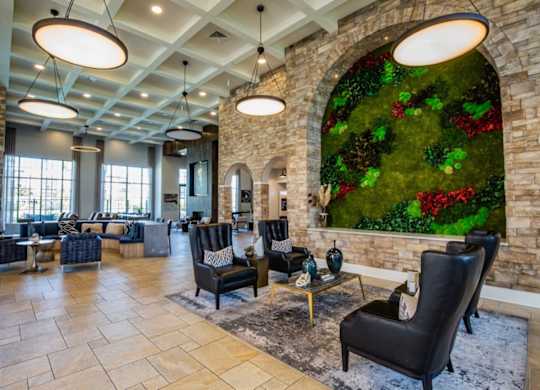 A living room with a green wall and black chairs.