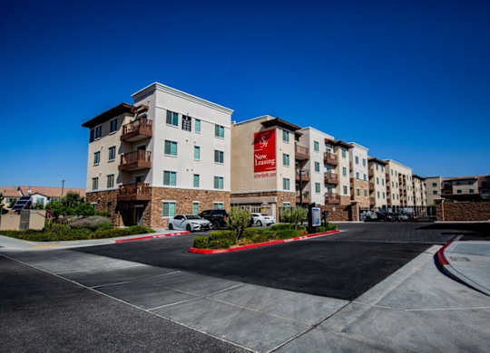 A large apartment complex with a red and white sign that says