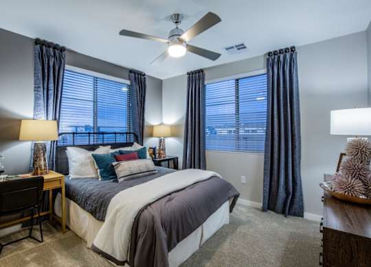 A bedroom with a bed, desk, and chair.