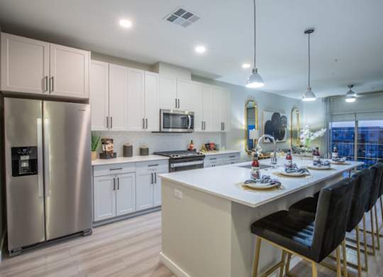 A modern kitchen with a large island and stainless steel appliances.
