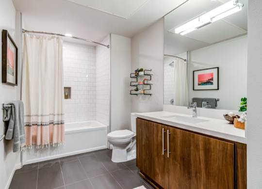 A bathroom with a toilet, sink, and a shower with a curtain.