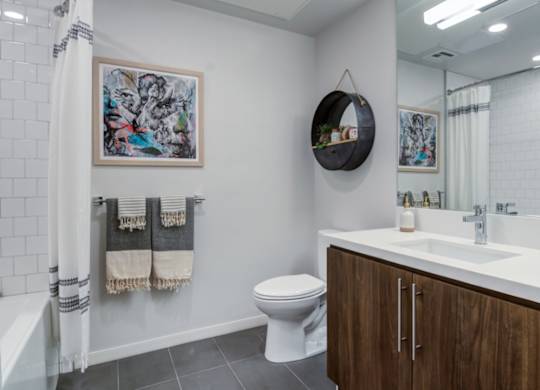 A bathroom with a toilet, sink, and a mirror.