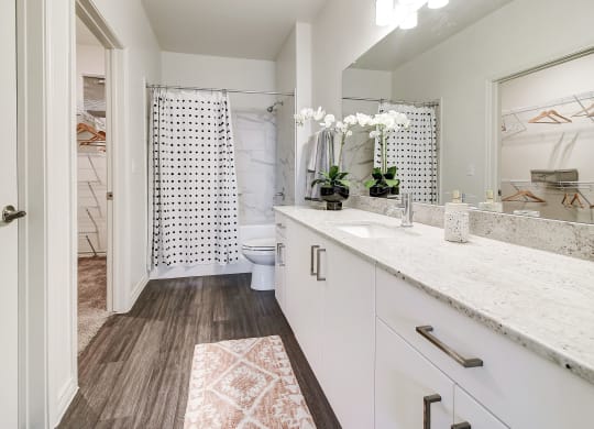 The Dylan  bathroom with white cabinets and a white shower curtain