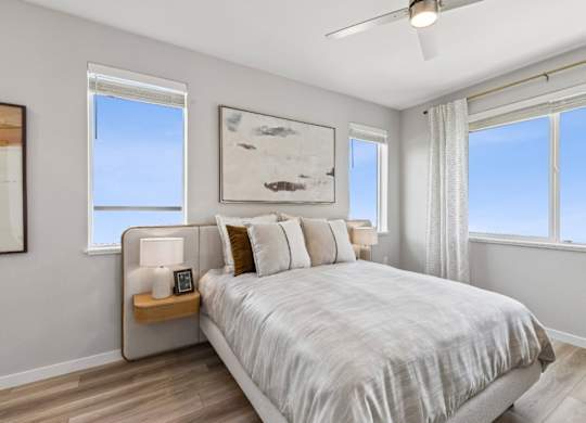 A bedroom with a large bed and a ceiling fan.