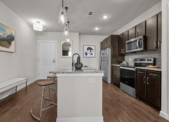 A kitchen with a white island and stainless steel appliances.