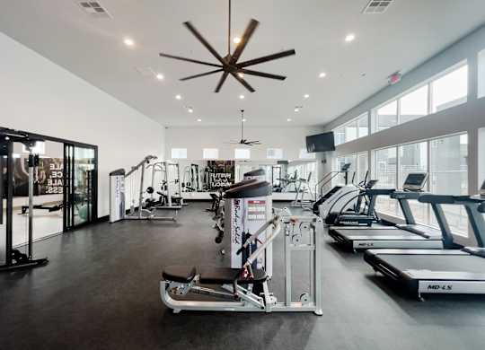 A gym with treadmills, weights, and exercise equipment.