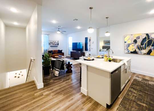 A modern kitchen with a wooden floor and white walls.