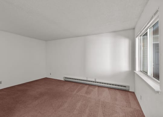 the living room of an empty house with carpet and two windows