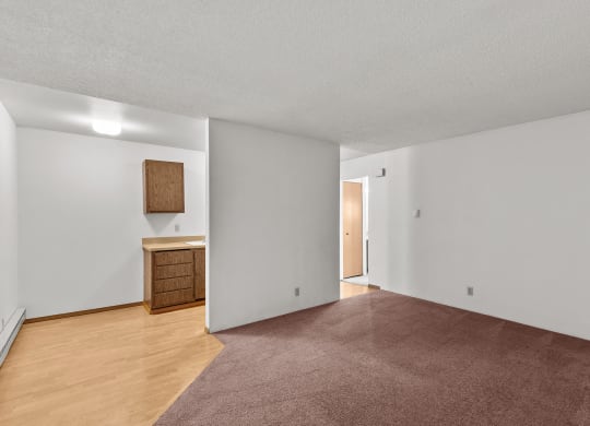 an empty living room with wood flooring and white walls