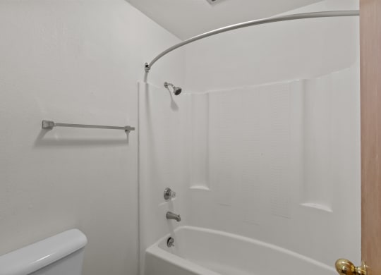 a white bathroom with a shower and a toilet
