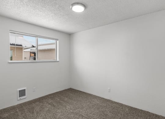 the living room of an apartment with a window and carpet