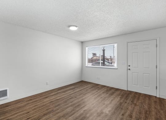 Creekside Apartments empty living room with white walls and wood flooring