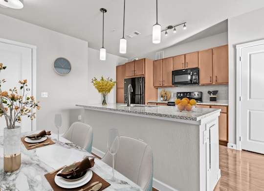 A modern kitchen with a marble table and chairs.