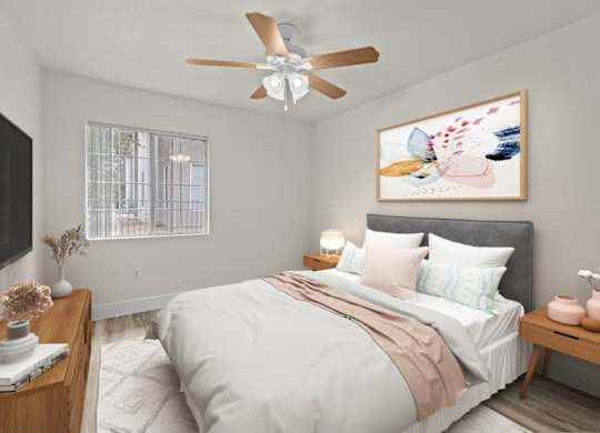 A bedroom with a bed, a ceiling fan, and a painting on the wall.