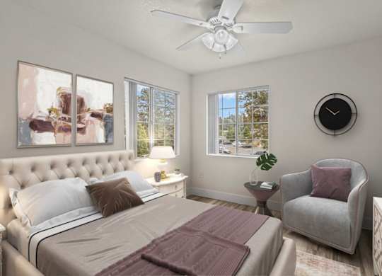 A bedroom with a large bed, a chair, and a ceiling fan.