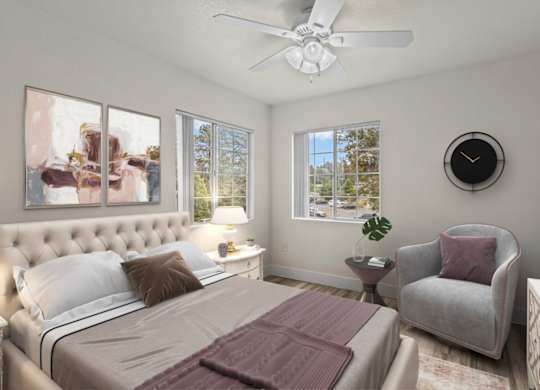 A bedroom with a large bed, a chair, and a ceiling fan.