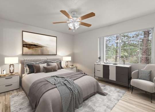 A bedroom with a large bed and a ceiling fan.