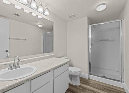 A bathroom with a sink, toilet, and shower.