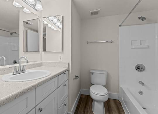 A white bathroom with a sink, toilet, and bathtub.