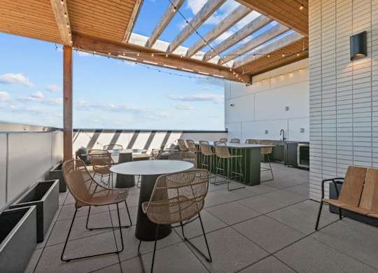 A patio with a table and chairs overlooking the ocean.